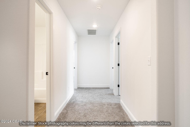 hallway with light colored carpet