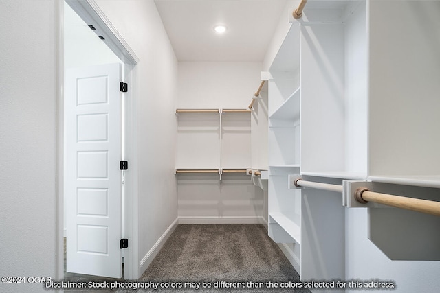 spacious closet featuring dark carpet