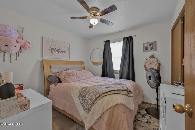 bedroom with ceiling fan, carpet flooring, and a closet