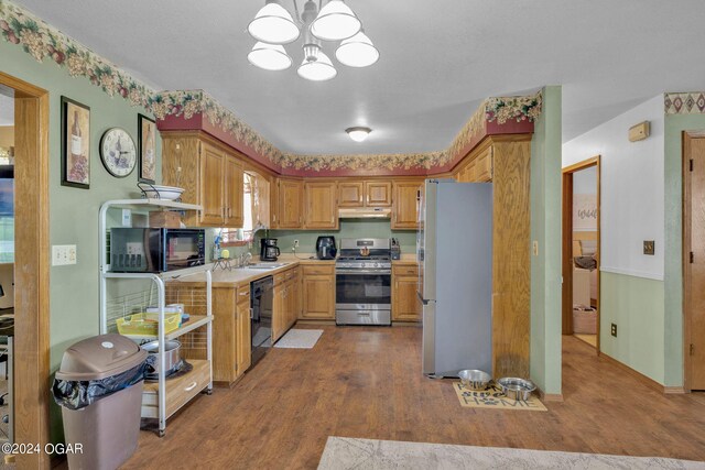 kitchen featuring a notable chandelier, hardwood / wood-style floors, and black appliances