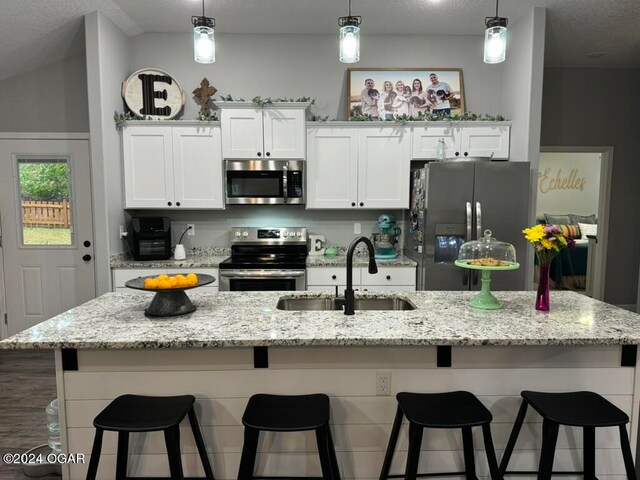 kitchen featuring a center island with sink, a breakfast bar area, and stainless steel appliances