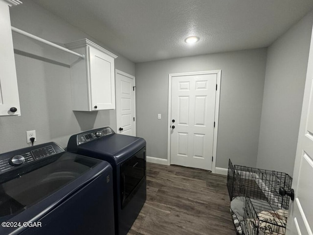 washroom with independent washer and dryer, cabinets, dark hardwood / wood-style flooring, and a textured ceiling