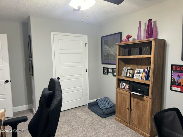 office space featuring ceiling fan, a textured ceiling, and light colored carpet