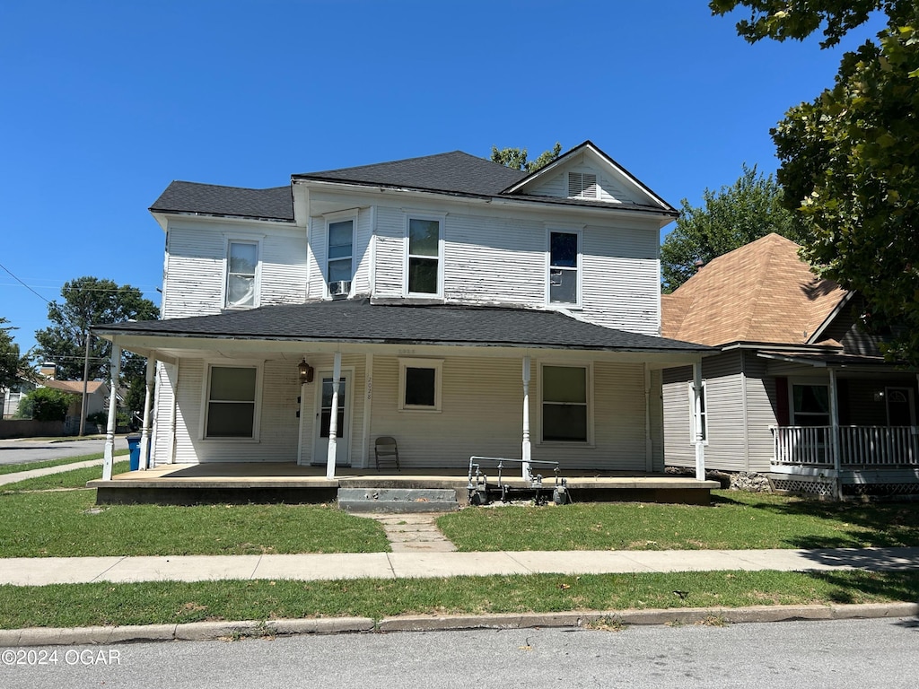 view of front of house featuring covered porch and a front lawn