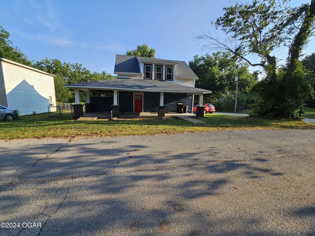 view of front of home with a porch and a front yard