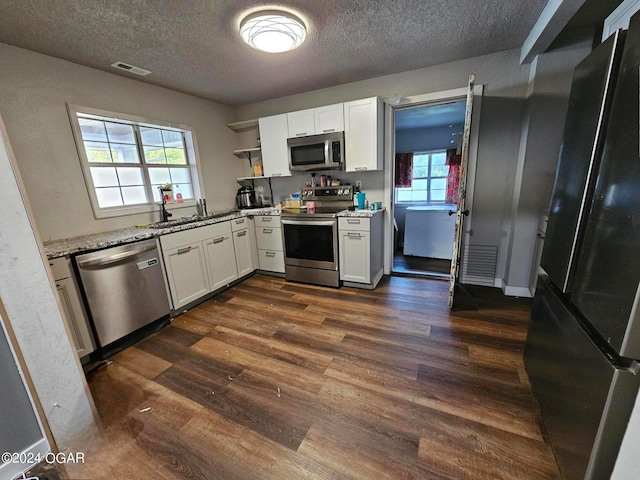 kitchen featuring stainless steel appliances, sink, white cabinetry, a textured ceiling, and dark hardwood / wood-style flooring