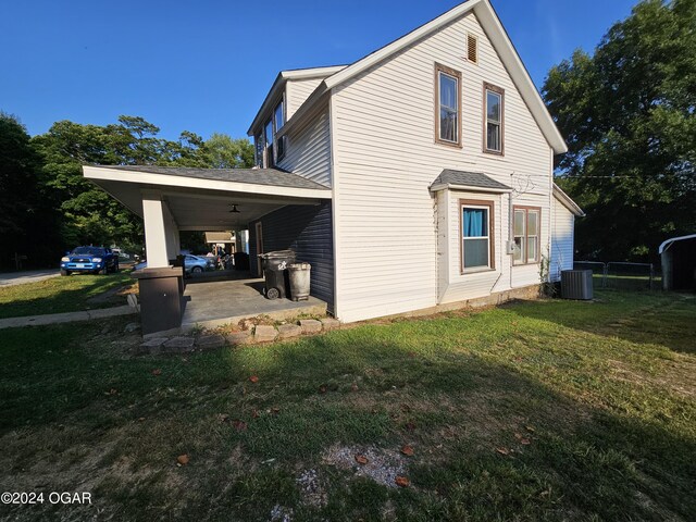 view of home's exterior featuring a lawn, a carport, and central AC unit