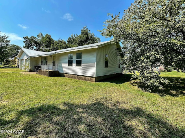 exterior space with metal roof and a yard