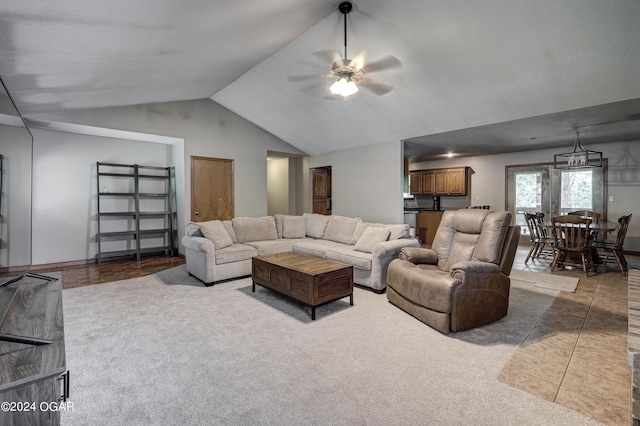 carpeted living area with lofted ceiling, tile patterned flooring, and ceiling fan