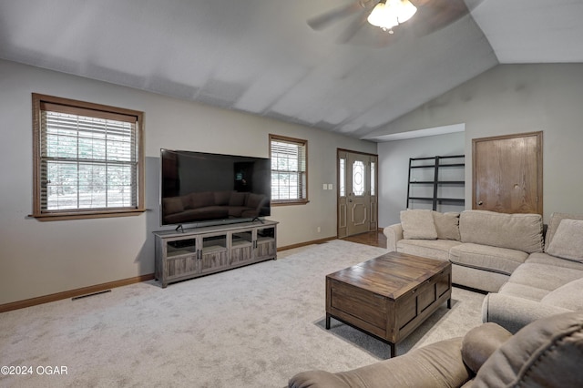 living area with carpet floors, visible vents, a ceiling fan, vaulted ceiling, and baseboards