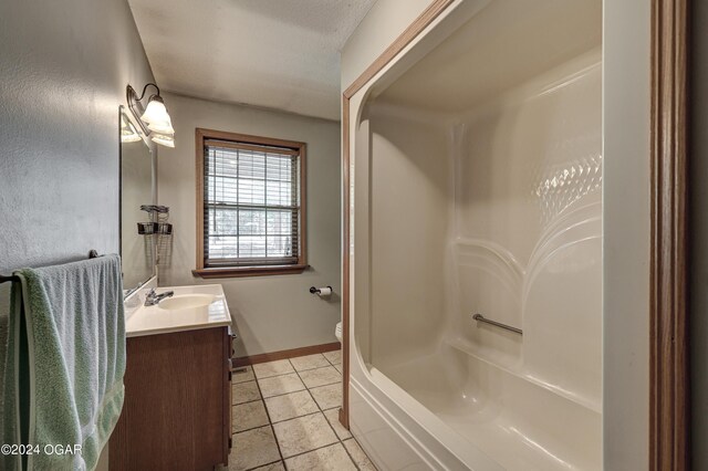 bathroom featuring tile patterned flooring, toilet, bathing tub / shower combination, vanity, and baseboards