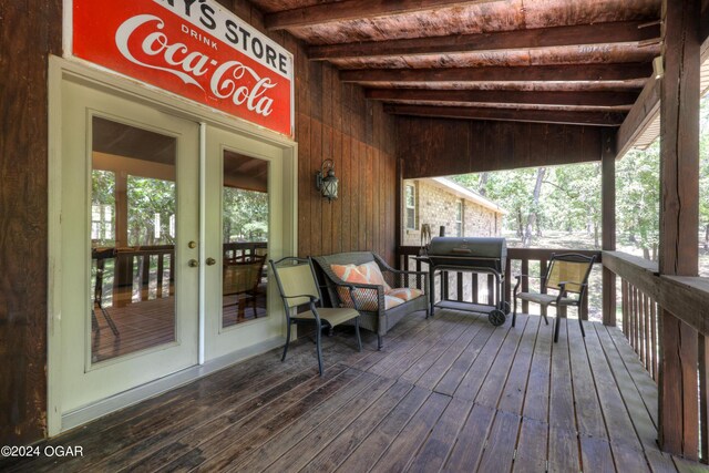 wooden deck featuring french doors and a grill