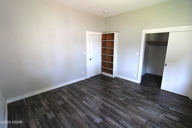 unfurnished bedroom featuring a closet and dark hardwood / wood-style flooring