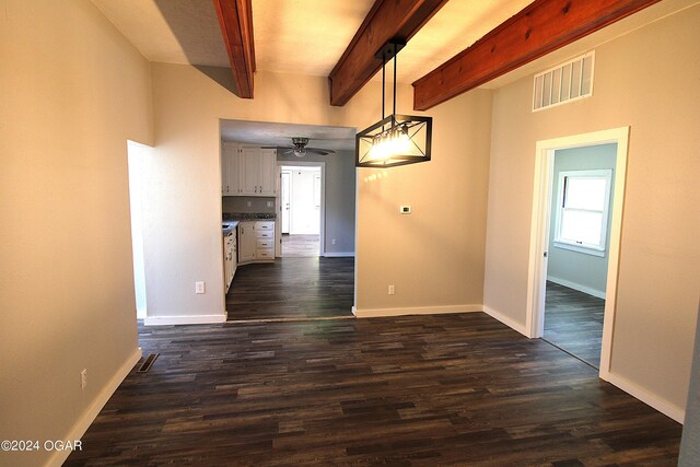 empty room featuring ceiling fan, beam ceiling, and dark wood-type flooring