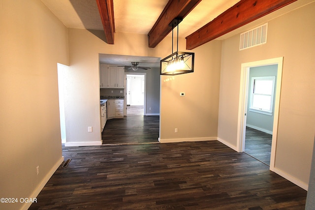 unfurnished dining area featuring beam ceiling, visible vents, dark wood finished floors, and baseboards