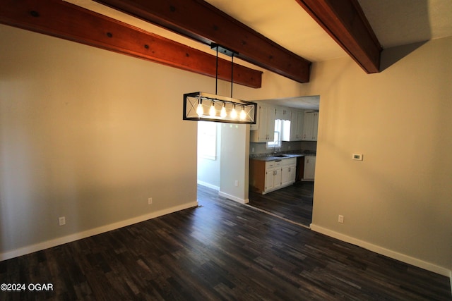 interior space with a sink, baseboards, dark wood finished floors, and beamed ceiling