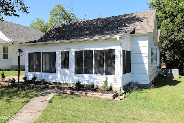 view of front facade featuring roof with shingles and a front yard