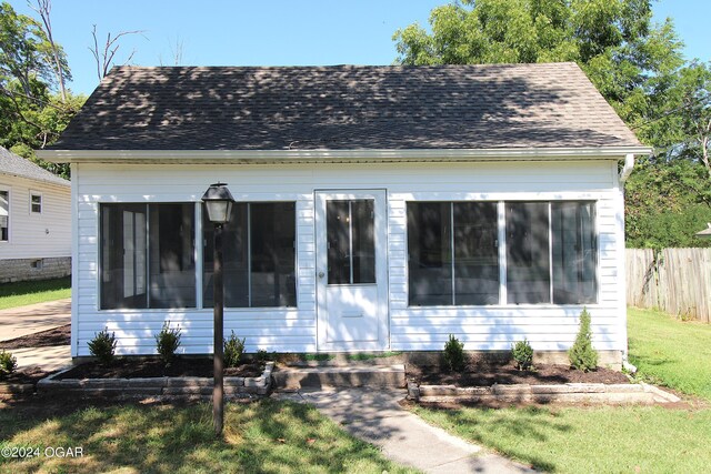 view of front of home featuring a front yard and a sunroom