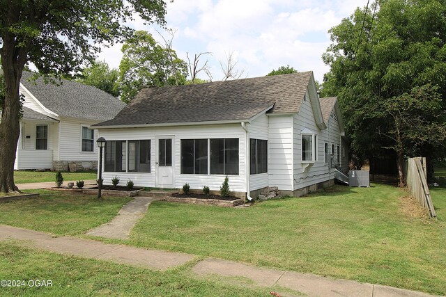 view of front facade featuring a front yard and central AC