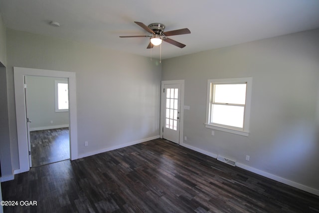 unfurnished room featuring a ceiling fan, baseboards, visible vents, and dark wood-type flooring