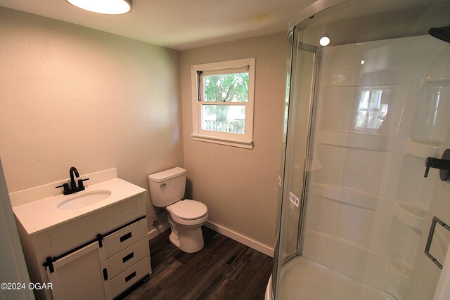 bathroom with a shower with door, toilet, hardwood / wood-style floors, and vanity