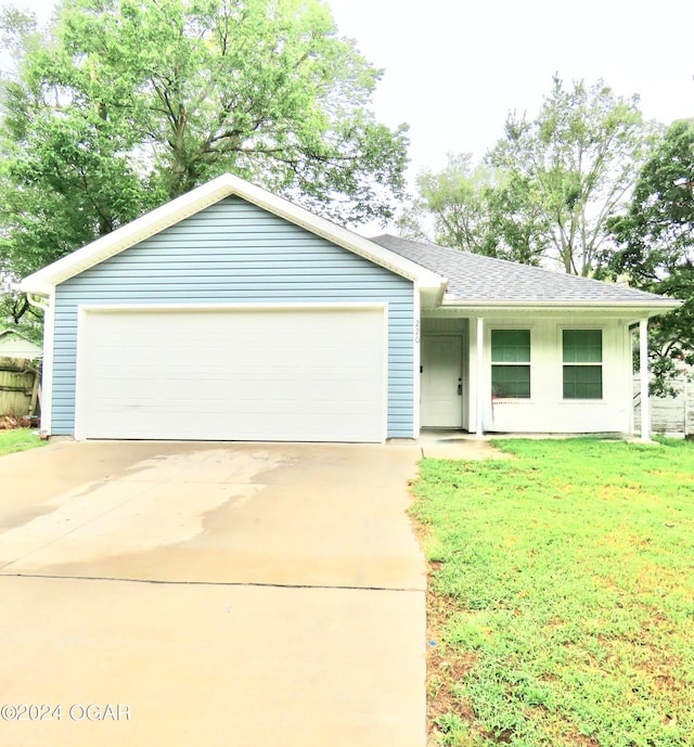 single story home with a garage and a front lawn