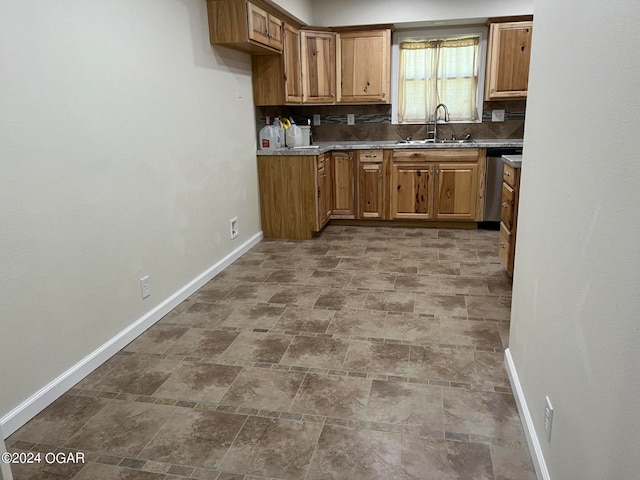 kitchen with sink, stone counters, tasteful backsplash, tile patterned flooring, and dishwasher