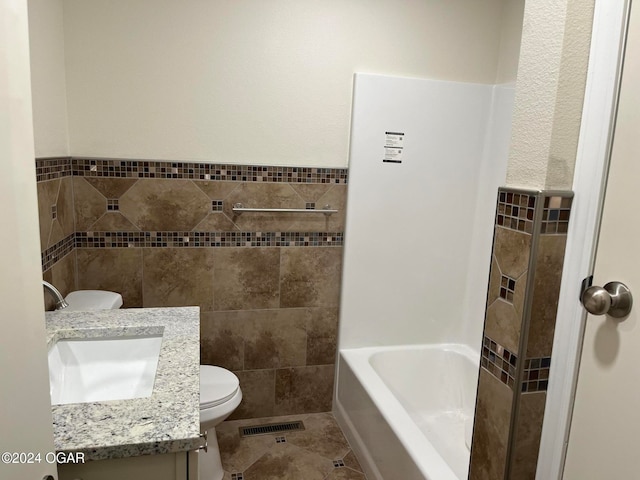 bathroom featuring toilet, tile walls, tile patterned floors, and vanity