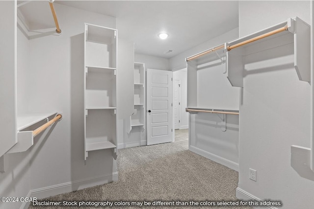 walk in closet featuring light carpet