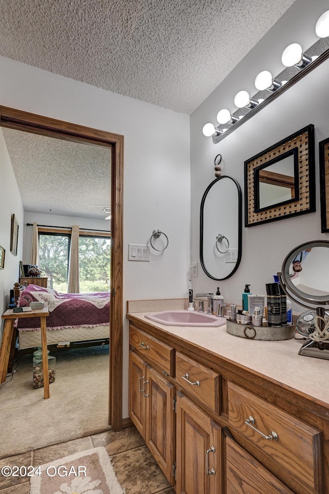 bathroom with vanity, a textured ceiling, and tile patterned flooring