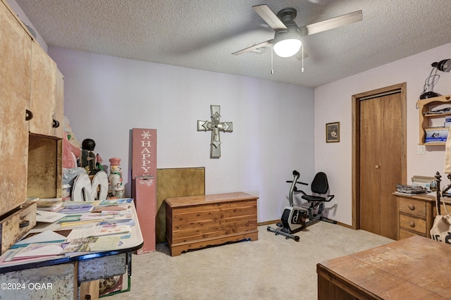 interior space featuring a textured ceiling, carpet flooring, and ceiling fan