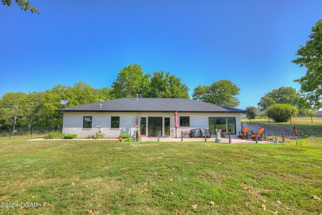 rear view of property with a lawn and a patio