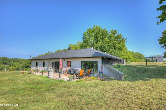 rear view of property with a yard and a patio