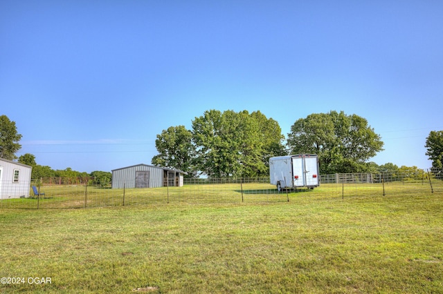 view of yard featuring an outdoor structure and a rural view