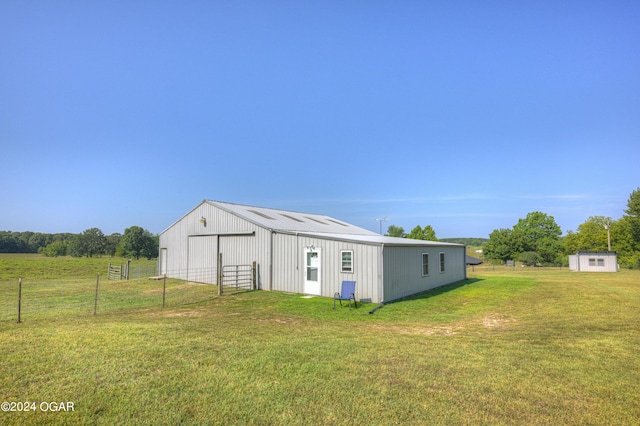 view of outdoor structure with a lawn and a rural view