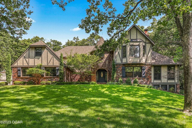 tudor-style house with a front lawn