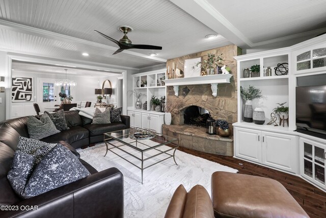 living room featuring ceiling fan with notable chandelier, a stone fireplace, dark hardwood / wood-style flooring, and built in features