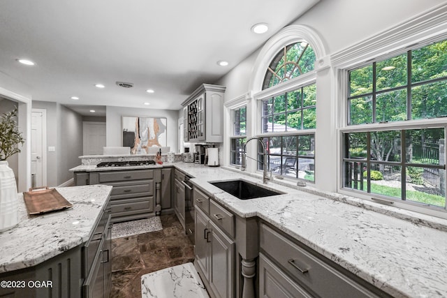 kitchen with stainless steel gas cooktop, gray cabinets, a sink, and recessed lighting