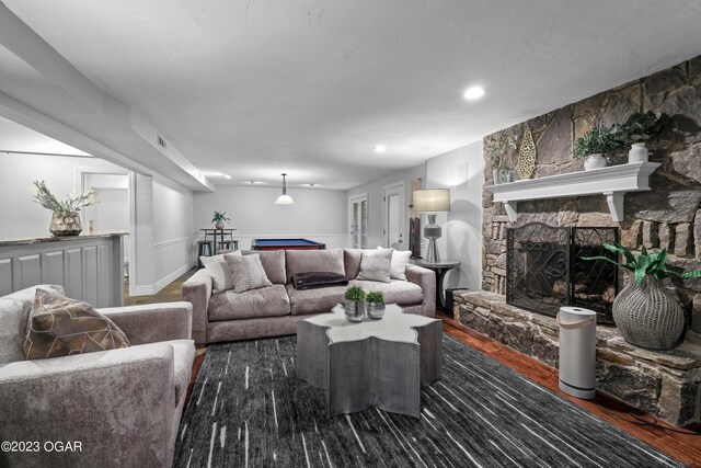 living room featuring a fireplace and dark wood-type flooring