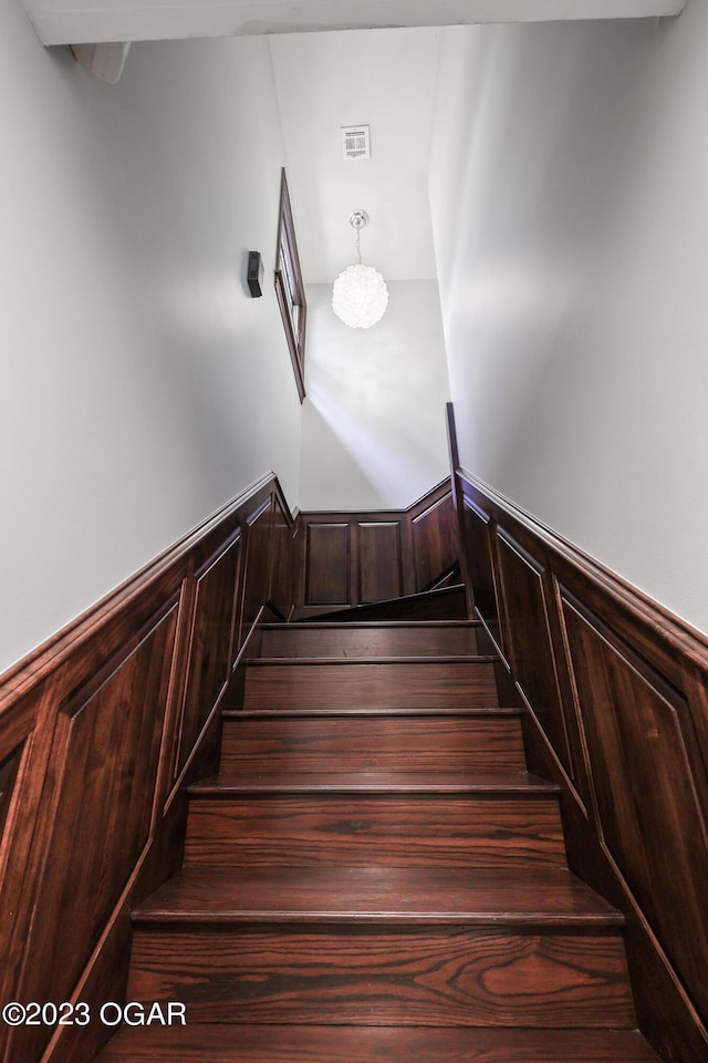 staircase with wainscoting and visible vents