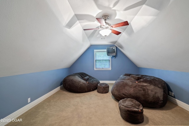 sitting room featuring ceiling fan, carpet floors, and vaulted ceiling