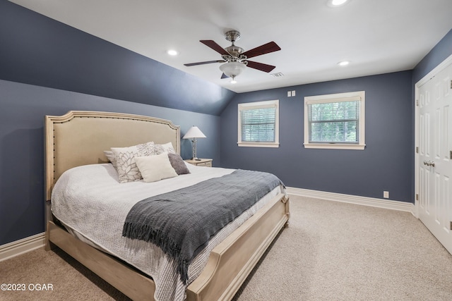 carpeted bedroom with ceiling fan, a closet, and vaulted ceiling