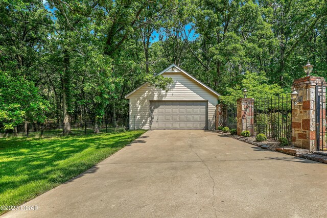 view of front of home featuring an outdoor structure, a garage, and a front lawn