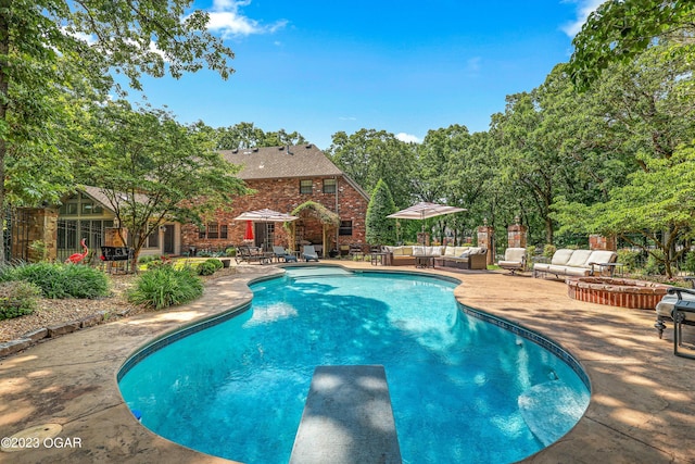 view of swimming pool with a diving board and a patio area