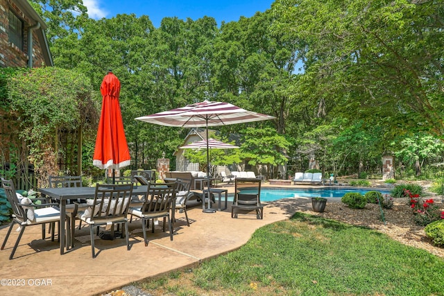 pool with outdoor dining space, fence, and a patio