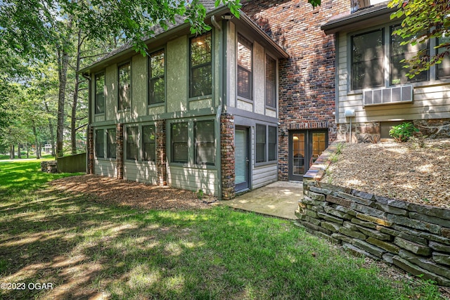 back of house with brick siding, a patio area, and a yard