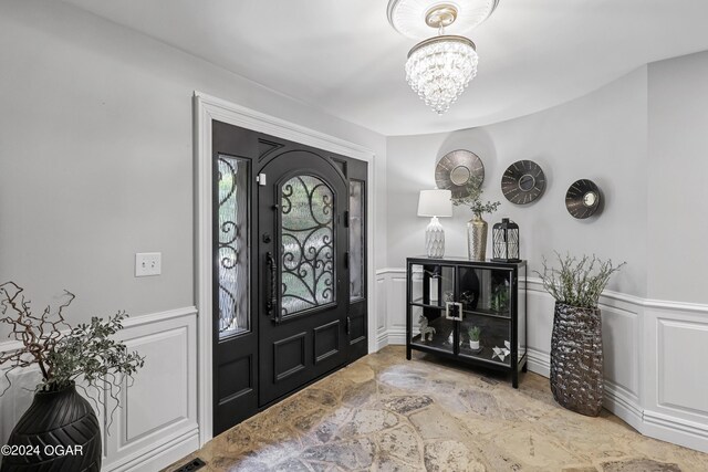 entryway with a notable chandelier and light tile patterned flooring