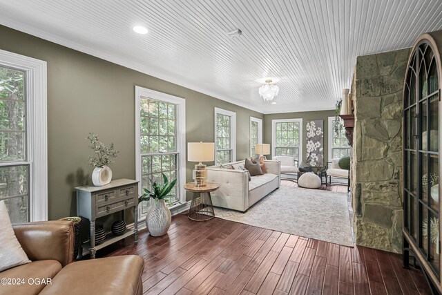 living room featuring a stone fireplace and dark wood-type flooring