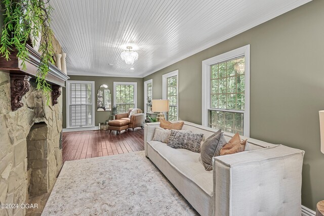 living room with a fireplace, crown molding, and wood-type flooring