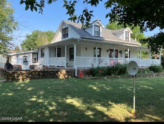 farmhouse featuring covered porch and a front yard